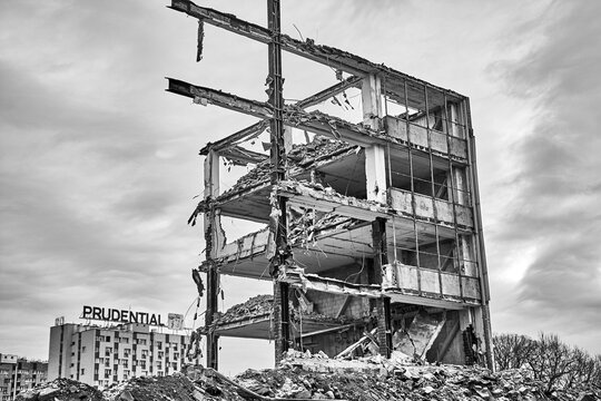 A partially demolished multi-story building skeleton with the Prudential sign visible in the background, Katowice, Slask, Poland, Europe.
