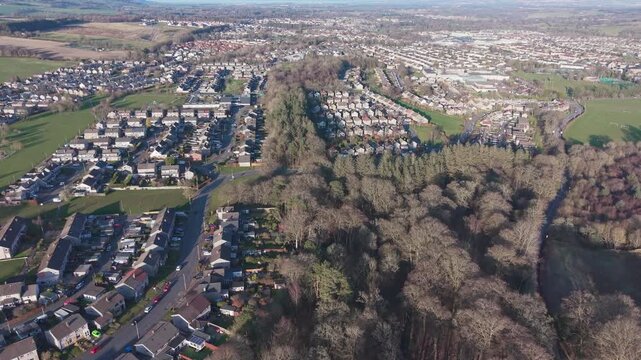 A scenic drone perspective of Penicuik townscape: A wide view of a Scottish residential settlement surrounded by green hills and fields