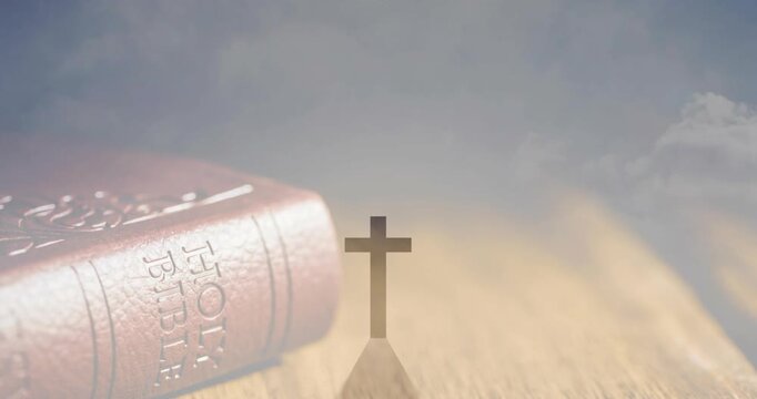 Cross emerging and casting long shadow as warm light rising, Bible gaining clarity for devotion