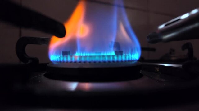 A gas stove burner with a blue and orange flame during the ongoing LPG crisis and rising cooking gas concerns