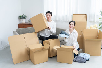 Fototapeta premium ダンボールに物を入れる夫婦（引越し・転居）