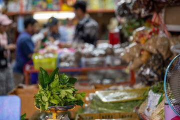 Fresh herbs weighed on scale at Bangkok wet market