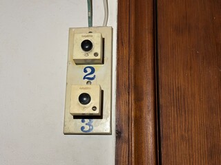 A classic vintage doorbell in a residential entrance used to alert residents of guests.