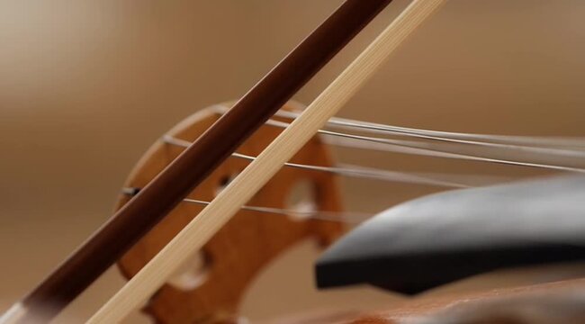 Closeup capturing the intricate details of a violin bow, strings, and bridge