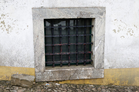 Evoramonte village window with stone frame and iron bars