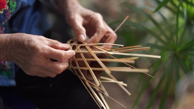 Elderly Hands Weaving Traditional Bamboo Strips to Make Handmade Basket, Asian Indigenous Craft Heritage