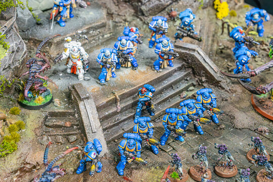 Detailed Warhammer diorama showing a rocky battlefield with armored figures in varying colors, set on a platform, naturalistic lighting, miniature landscape elements - Kyiv, Ukraine - June 7, 2025
