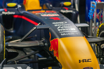 Fototapeta premium Formula 1 car against blurred background, TAG Heuer and Infiniti sponsor logos, red, black, yellow color scheme, front wing, aerodynamic nose section, indoor environ - Kyiv, Ukraine - June 7, 2025