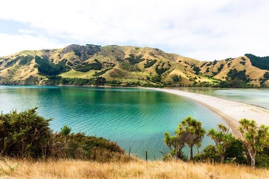 view across clear green water and causeway to a mountainous island