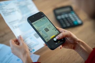 Person scanning utility bill with smartphone for online banking