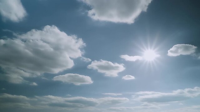 The sun's rays pierce through dramatic clouds in a vast blue sky.