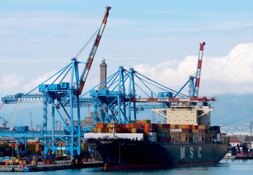 Genoa, Italy - February 2026: a container ship of the MSC shipping company moored at the Sech terminal. In the background, the historic lighthouse of the port city. 
