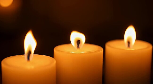 Three elegantly glowing candles cast a warm and intimate light in darkness