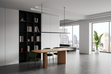 Modern interior office space with wooden table, green chairs, bookshelves and large windows overlooking cityscape in minimalist design. 3D Rendering © ImageFlow