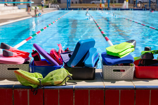 baskets filled with swim training equipment like flippers and snorkels with lane ropes in background