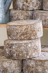 Naklejka premium Stacks of traditional artisanal cheese wheels at a local market
