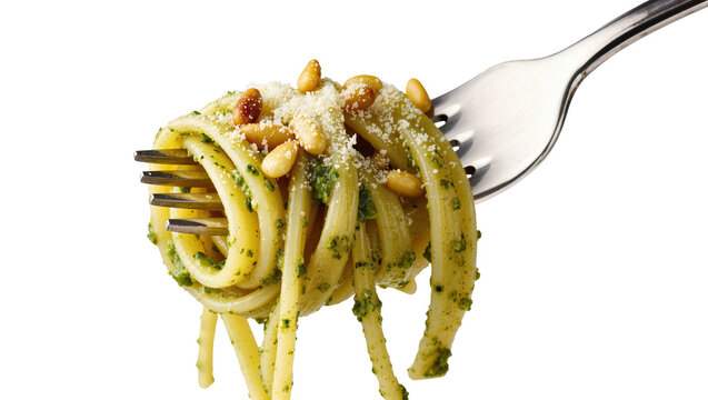 Isolated spaghetti with vibrant pesto, grated cheese, and pine nuts on shiny metal fork.