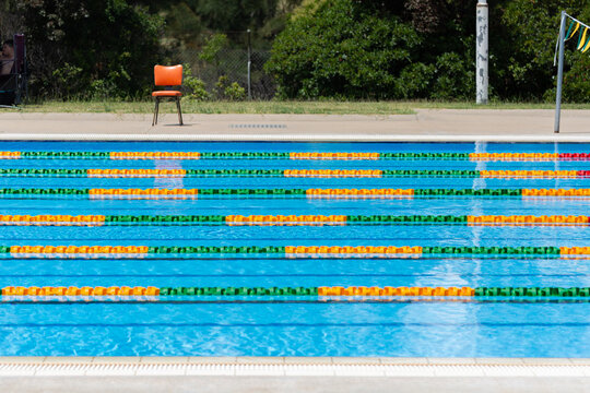 Colourful lane ropes set up in a public swimming pool and chair waiting for a swim competition