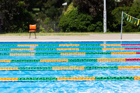 Colourful lane ropes set up in a public swimming pool and chair waiting for a swim competition