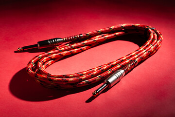 red instrumental audio cable on red background