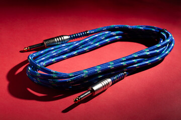 blue instrumental audio cable on red background
