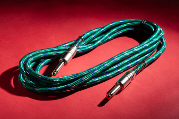 green instrumental audio cable on red background
