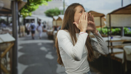 Fototapeta premium Woman cups hands around mouth calling on street restaurant terrace outdoors; announcement excitement.