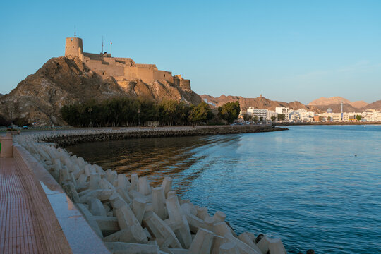 Waterfront cityscape in Muscat Oman during golden hour, Muscat fort, muttrah souq and corniche roads, Visit muscat travel background 
