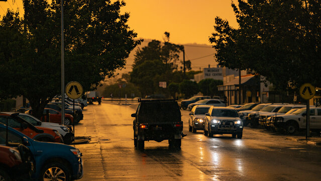 Cars stopped at pedestrian crossing along street in heavy rain