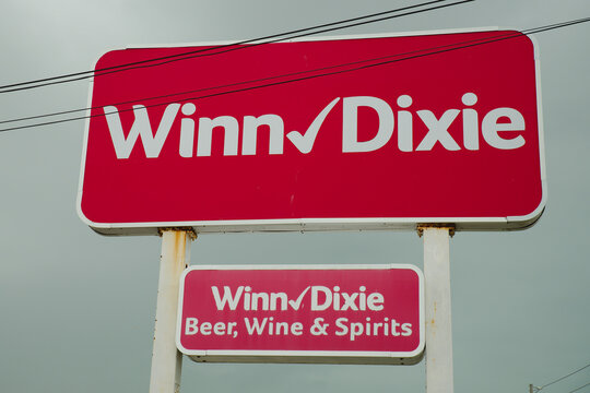 Winn-Dixie Store Signboard With Beer, Wine & Spirits Branding Against Overcast Sky Editorial Use Only, March 13, 2026, St. Petersburg, FL USA. Grocery store pole sign against a gray overcast sky, conv