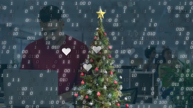 Animation of binary coding and christmas decorations over businessman in office