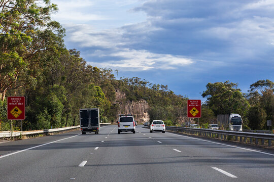 reduce speed when wet slippery road sign on highway in dry weather