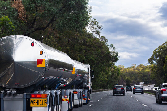 Shiny reflective tanker truck traveling down highway road in NSW Australia