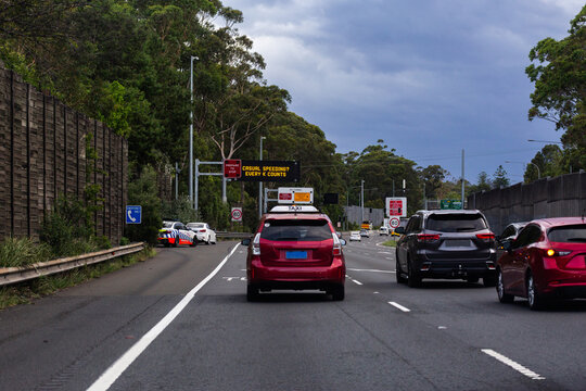 car pulled over by police with traffic passing and casual speeding? Every k counts sign