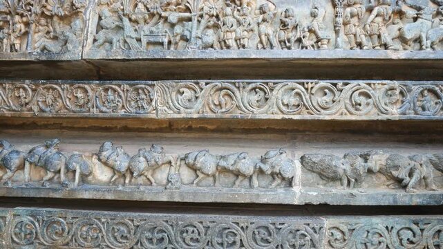 Detailed stone carving Halebeedu ancient temple Karnataka India showing warriors deities animals intricate sculptural art symbolizing heritage culture devotion