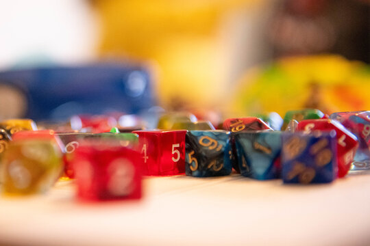 Multi-sided Dungeons and Dragons dice scattered across a table in a colorful, atmospheric close-up of tabletop RPG culture, fantasy gaming, and game night adventure.