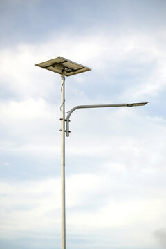 Solar powered street light against cloudy sky