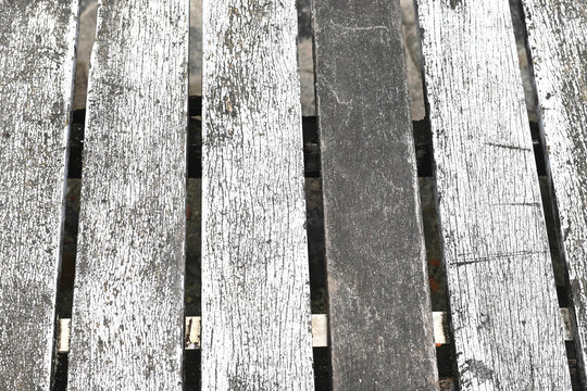 Weathered wooden planks with peeling white paint