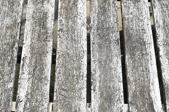 Weathered wooden planks with peeling white paint
