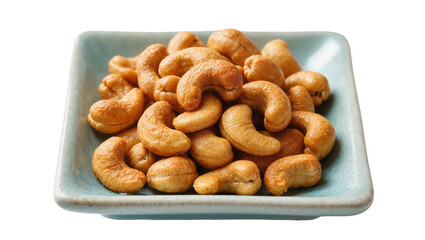 Fototapeta premium Isolated pile of delicious roasted cashew nuts in a blue ceramic dish, healthy snack food