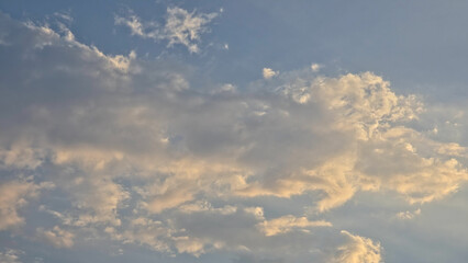 Obraz premium A serene blue sky filled with soft, scattered white and grey clouds.