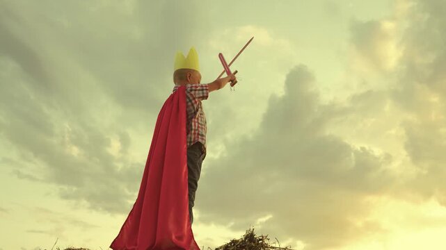happy family. little boy playing with ball sunset wearing golden paper crown. chidhood dream. kid child plays park against sky. superhero child red cape. superhero child play concept.outdoors. chid.