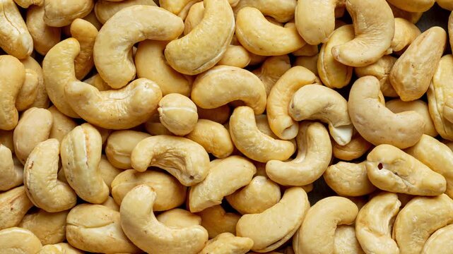 High-resolution macro view of natural cashew nuts filling the frame. Healthy organic snack ingredient background perfect for food industry, nutrition themes, grocery advertising, packaging design.