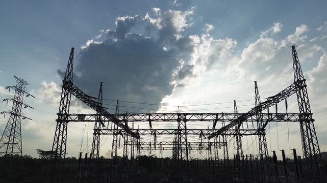 Aerial drone footage of high voltage transmission towers and power lines during perfect natural light afternoon with dynamic movement and diverse angles for energy infrastructure visuals.
