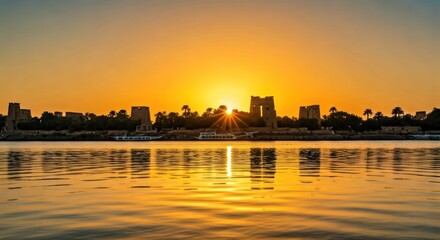 Ancient temple silhouettes reflect in calm water at sunrise, bathed in golden light