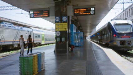 Train platform with defocused carriages, signage and nopeople, rendered in soft bokeh with shallow...