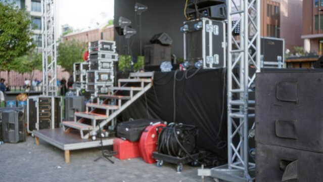 Concert stage and audio equipment softly blurred bokeh outdoor; background backdrop copyspace template.