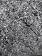 Naklejka premium Grey Dark rough rock texture with natural stone patterns and gritty surface details for backgrounds 
