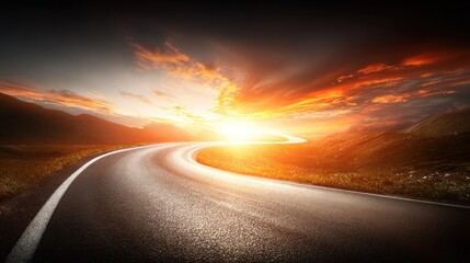 Fototapeta premium Winding asphalt road leading towards a bright, fiery sunset over rolling hills