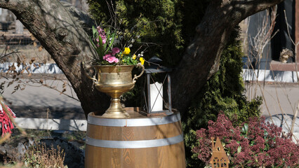Obraz premium Vase, lantern, and barrel by a blossoming spring tree